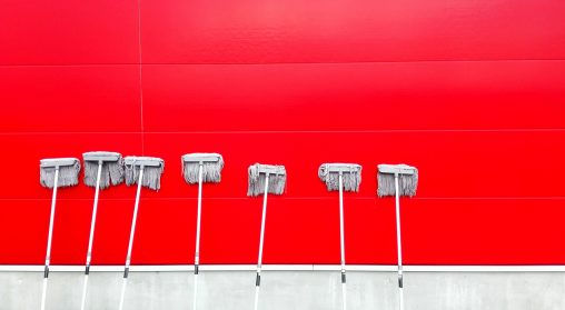 What to Look For in a Commercial Cleaning Company. Mops leaning against a red wall