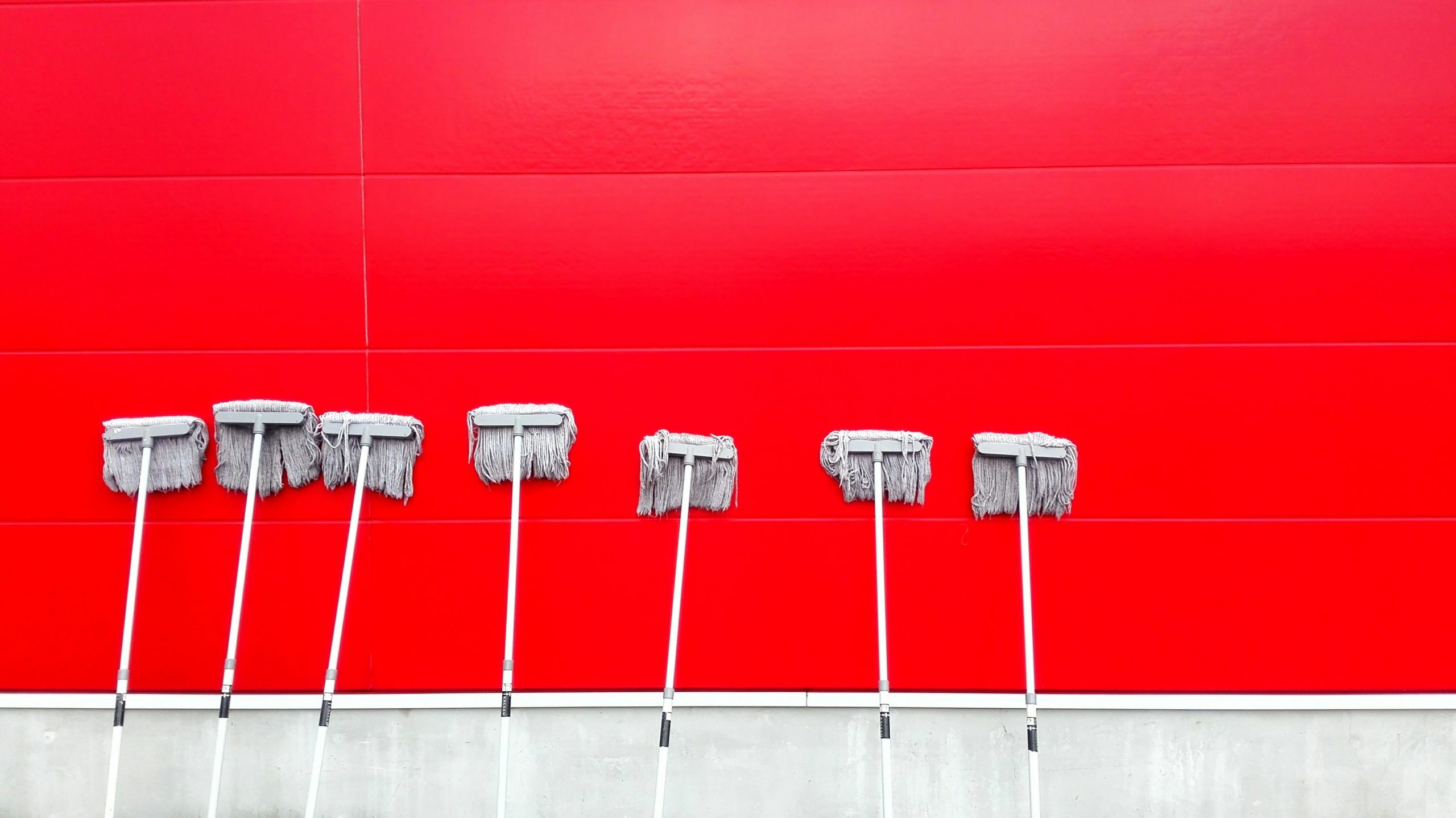 What to Look For in a Commercial Cleaning Company. Mops leaning against a red wall